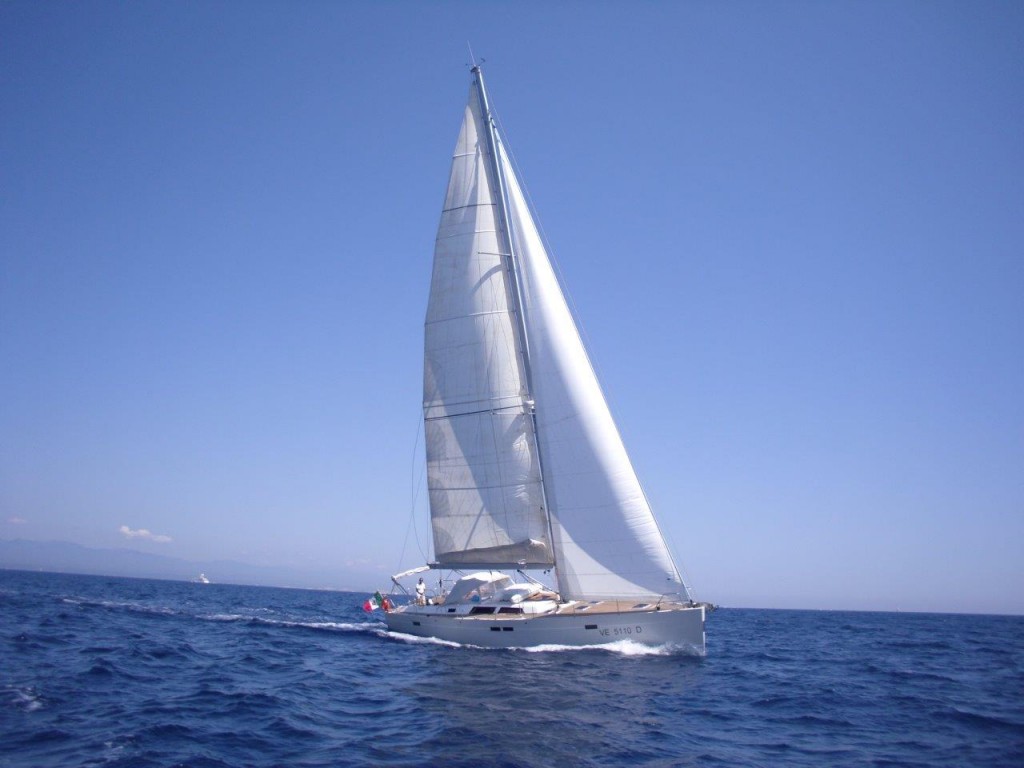 A sailboat sailing upwind on a perfect day in Ibiza. 